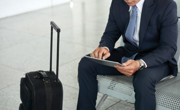 Businessman using Tablet Computer in Airport